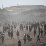 Starved Gaza residents forced to pick airdropped rice mixed with sand